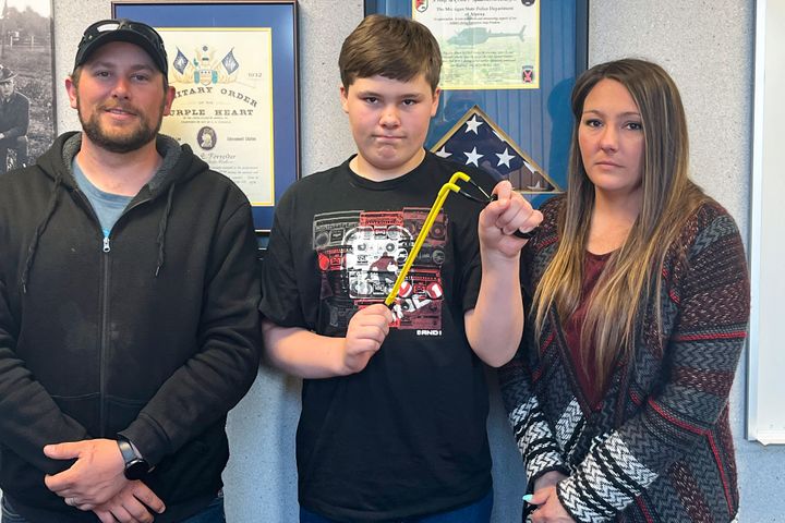 Andrew Burns, Owen Burns, and Margaret Burns pose with a slingshot Owen used to thwart an alleged kidnapping attempt of his sister.