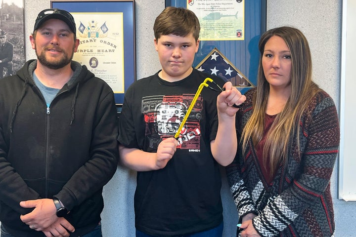 Andrew Burns, Owen Burns, and Margaret Burns pose with a slingshot Owen used to thwart an alleged kidnapping attempt of his sister.