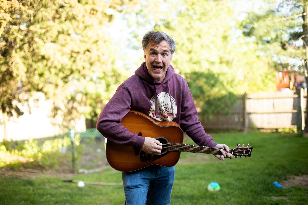 Farley plays a guitar at his home on Wednesday in Danvers, Massachusetts. Farley has so far tackled 46 states with his ongoing "Cities & Towns" project.