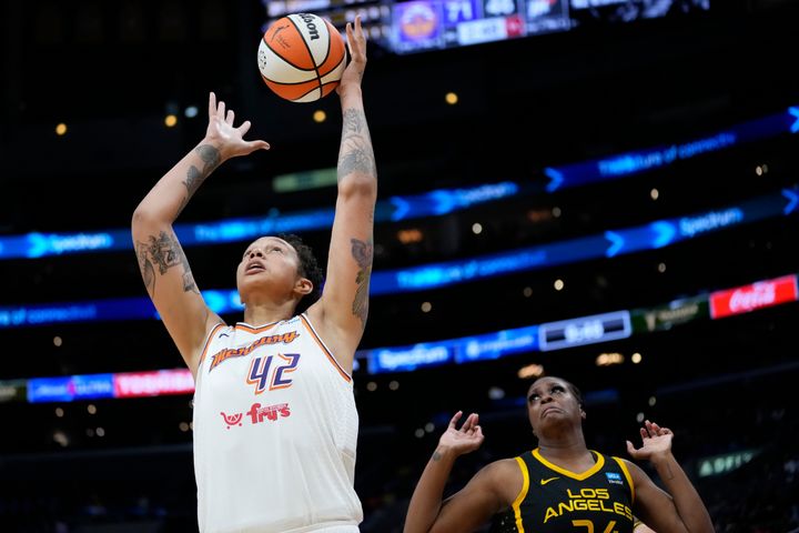 Phoenix Mercury center Brittney Griner jumps up for a rebound against Los Angeles Sparks Joyner Holems during the second half of a game in Los Angeles on Friday. Griner had 18 points, six rebounds and four blocked shots in her team's 94-71 loss to open the WNBA season.
