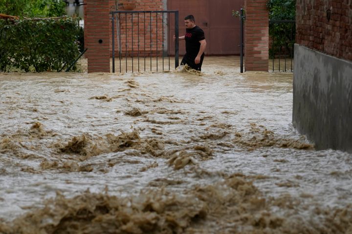A man walks in a flooded street in the village of Castel Bolognese, Italy, Wednesday, May 17, 2023.
