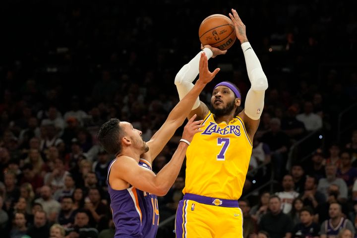 Los Angeles Lakers player Carmelo Anthony (7) scores against Phoenix Suns' Landry Shamet during the first half of their NBA game, on April 5, 2022, in Phoenix.