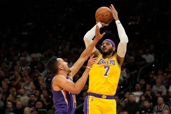 Los Angeles Lakers player Carmelo Anthony (7) scores against Phoenix Suns' Landry Shamet during the first half of their NBA game, on April 5, 2022, in Phoenix.