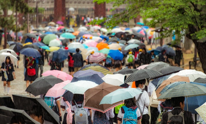 雨の中、傘をさす人たち