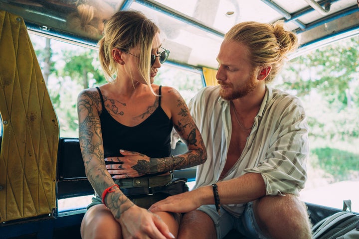 Couple is riding in a local Thai taxi and the woman is feeling a stomachache.