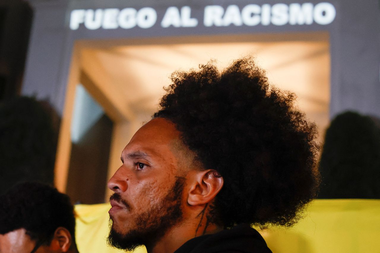 Βραζιλία: Ένας φιλαθλος μπροστά από μια πινακίδα που γράφει "Φωτιά στον ρατσισμό", καθώς διαμαρτύρεται σε ένδειξη αλληλεγγύης προς τον ποδοσφαιριστή της Ρεάλ Μαδρίτης Vinicius Jr, ο οποίος κακοποιήθηκε ρατσιστικά κατά τη διάρκεια ενός αγώνα στην Ισπανία, κοντά στο προξενείο της Ισπανίας στο Σάο Πάολο , Βραζιλία 23 Μαΐου 2023. REUTERS/Amanda Perobelli