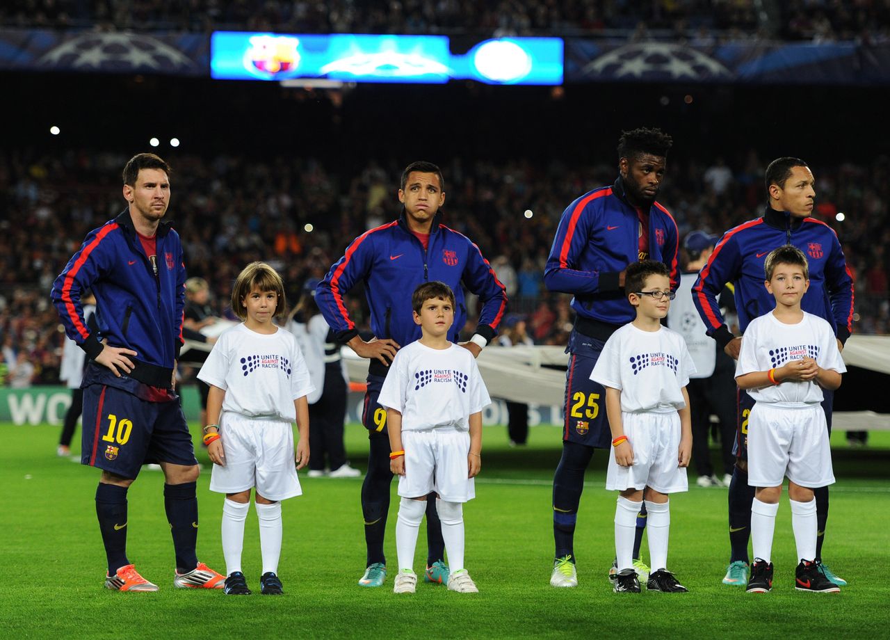 ΒΑΡΚΕΛΩΝΗ, ΙΣΠΑΝΙΑ - 23 ΟΚΤΩΒΡΙΟΥ: Παιδιά φορούν μπλουζάκι με το σύνθημα «Ενωμένοι ενάντια στον ρατσισμό» για την εβδομάδα δράσης FARE με τους (L-R) Lionel Messi, Alexis Sanchez και Javier Mascherano της Μπαρτσελόνα κατά τη διάρκεια του αγώνα του UEFA Champions League μεταξύ της FC Barcelona και Celtic FC στο στάδιο Camp Nou στις 23 Οκτωβρίου 2012 στη Βαρκελώνη, Ισπανία. (Photo by Jasper Juinen/Getty Images)