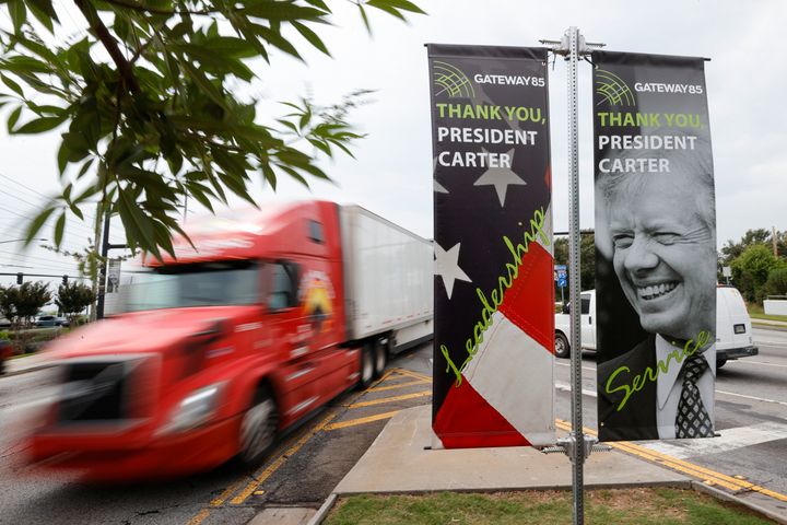 Motorists pass a sign dedicated to former President Jimmy Carter along Jimmy Carter Blvd. on May 23, 2023, in Norcross, Ga.