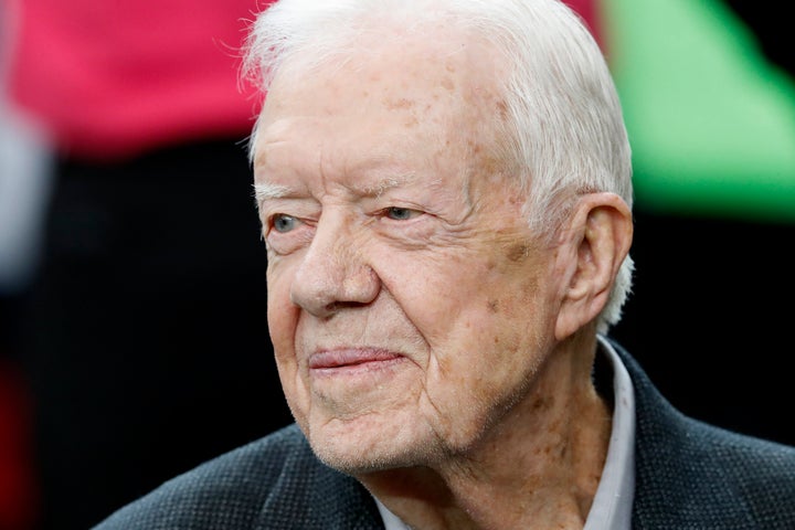 El expresidente Jimmy Carter se sienta en el banco de los Atlanta Falcons antes de la primera mitad de un partido de fútbol americano de la NFL entre los Atlanta Falcons y los San Diego Chargers, el 23 de octubre de 2016, en Atlanta.