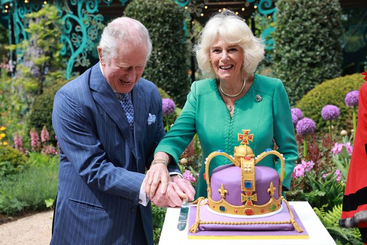 King Charles III and Queen Camilla laugh as they cut a cake during a visit to open the new Coronation Garden on day one of their two-day visit to Northern Ireland on May 24.