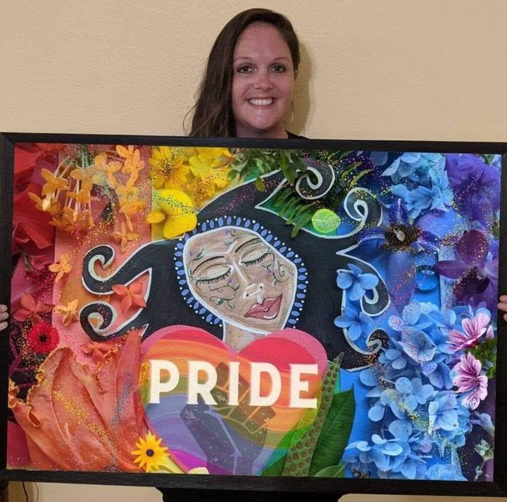 The author, here "40-something," holds her Pride Goddess painting. "I'm embracing a queer spirituality," she writes.