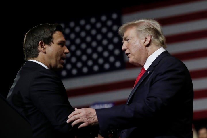 Donald Trump and Ron DeSantis talk to each other at a 2018 "Make America Great Again" rally in Tampa, Florida, when DeSantis was running for governor.