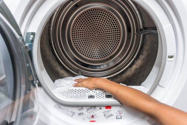 Removing clean clothes from a washing machine, Nigran, Pontevedra, Galicia, Spain