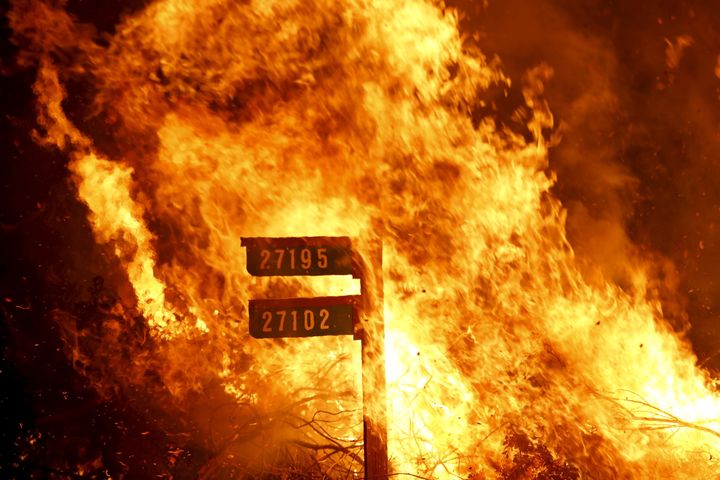 Flames from the Jerusalem Fire consume a sign containing addresses to homes in Lake County, California, in 2015. Major wildfires in California, and losses in the billions of dollars, have led some big insurance companies to stop writing homeowners policies for households that are considered at high risk of fire. 