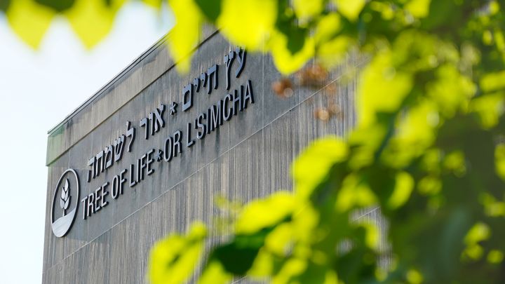 The signage on the dormant landmark Tree of Life synagogue in Pittsburgh's Squirrel Hill neighborhood is framed in spring foliage on April 19, 2023. 