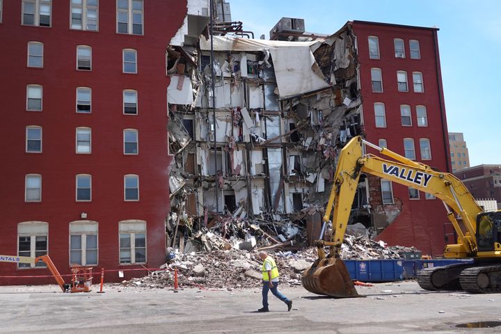 A worker walks by the six-story Davenport, Iowa, apartment building after it collapsed.
