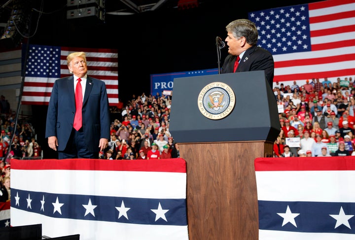 In 2018, President Donald Trump listens to Fox News' Sean Hannity speak during a rally in Cape Girardeau, Missouri.