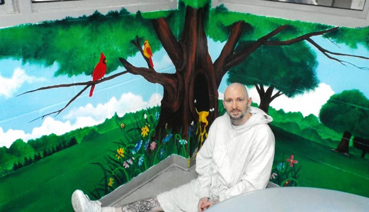 Michael Tisius pictured in front of a mural he painted.