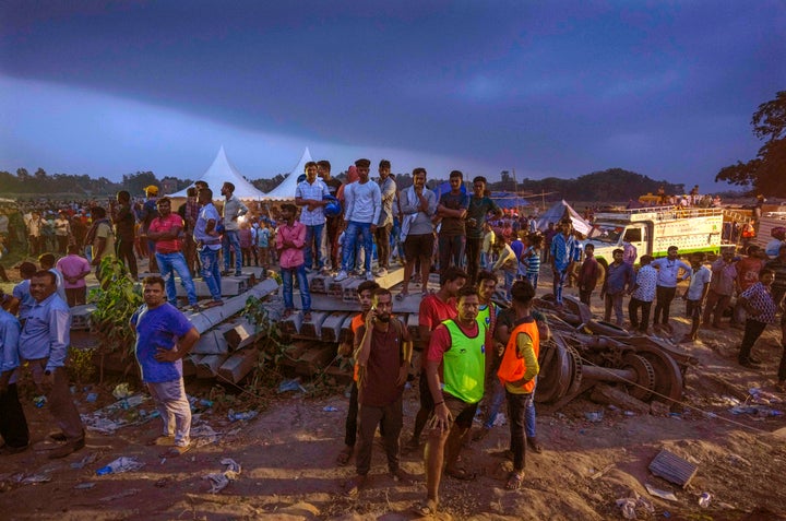 People watch rescue operations at the site of passenger trains that derailed in Balasore district, in the eastern Indian state of Orissa, Saturday, June 3, 2023. (AP Photo/Rafiq Maqbool)