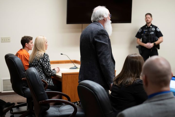 Latah County Prosecutor Bill Thompson, standing, addresses a court in Moscow, Idaho, during a hearing for Bryan Kohberger, left, who is accused of killing four University of Idaho students.