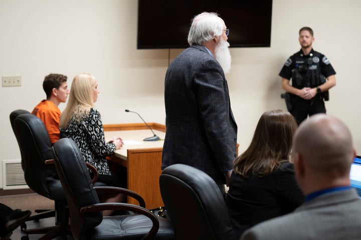 Latah County Prosecutor Bill Thompson, standing, addresses a court in Moscow, Idaho, during a hearing for Bryan Kohberger, left, who is accused of killing four University of Idaho students.