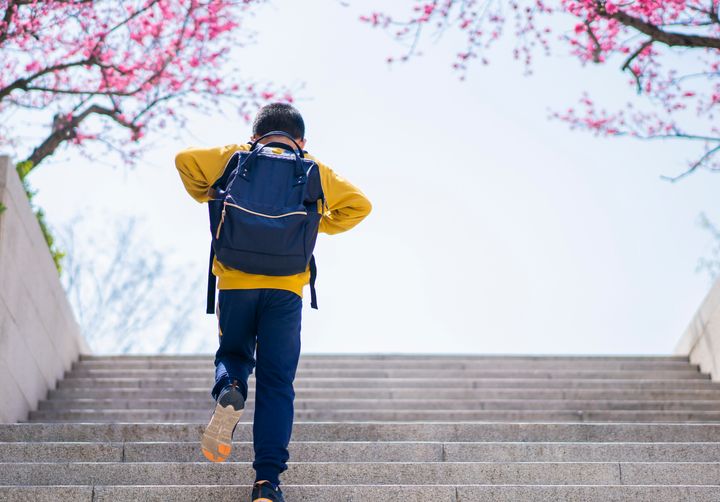 Boy with school bag going up steps