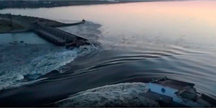 In this image taken from video released by the Ukrainian Presidential Office, water runs through a breakthrough in the Kakhovka dam in Kakhovka, Ukraine, on June 6, 2023. 