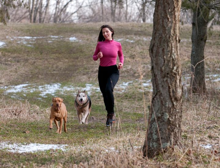 The author and her dogs, Lucinda (left) and Scruggs, now run in the woods, where everyone can go their own speed.