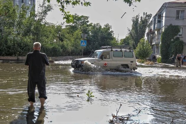 ヘルソン市内の浸水した道路で車を運転する赤十字のボランティアたち（2023年6月6日）