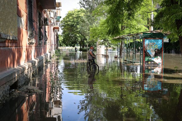 浸水したヘルソン市内で自転車を持つ住民（2023年6月6日）