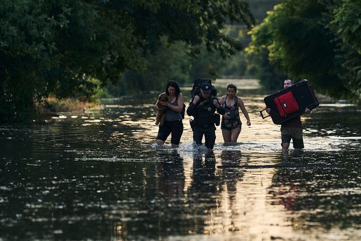 2023年6月6日、ヘルソン市の浸水した地域から荷物を持って避難する地元住民ら