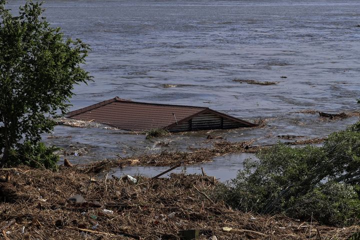 The roof of a house is seen in the Dnipro river which flooded after the Nova Kakhovka dam breached.
