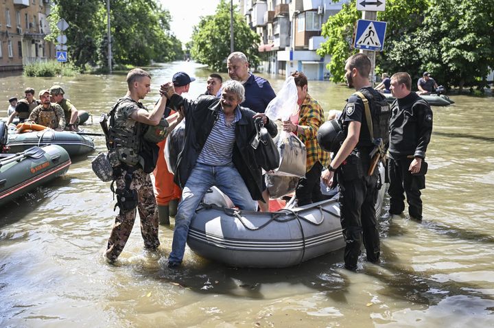Officials help people to evacuate their homes after the explosion at the Kakhovka hydropower plant flooded the houses and streets in Kherson, Ukraine on June 7, 2023.