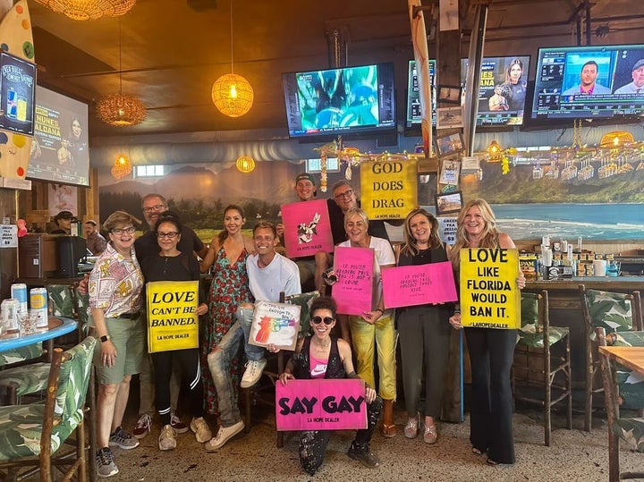 Corie Mattie, below center, with queer-owned and -allied business people who have assisted her in the project.