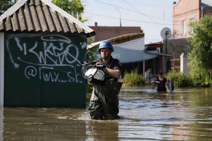 A rescuer helps to save belongings of locals from flooding following the destruction of the Kakhovka dam, on June 7, 2023 in Kherson, Ukraine.