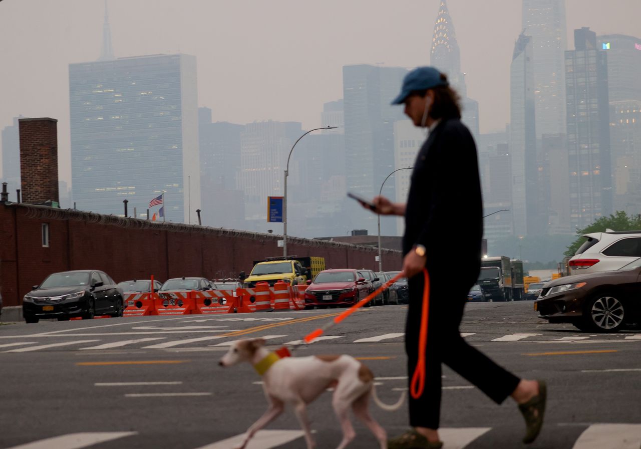 ΝΕΑ ΥΟΡΚΗ, ΗΝΩΜΕΝΕΣ ΠΟΛΙΤΕΙΕΣ - 6 ΙΟΥΝΙΟΥ: Ένας άνδρας βγάζει βόλτα τον σκύλο του καθώς η ποιότητα του αέρα παραμένει κακή στη Νέα Υόρκη, στις 06 Ιουνίου 2023. Η πόλη της Νέας Υόρκης εξέδωσε μια ειδική οδηγία υγείας για την Τρίτη, καθώς ο καπνός από τις πυρκαγιές στον Καναδά επηρεάζει την ατμόσφαιρα σοβαρά. (Photo by Selcuk Acar/Anadolu Agency via Getty Images)