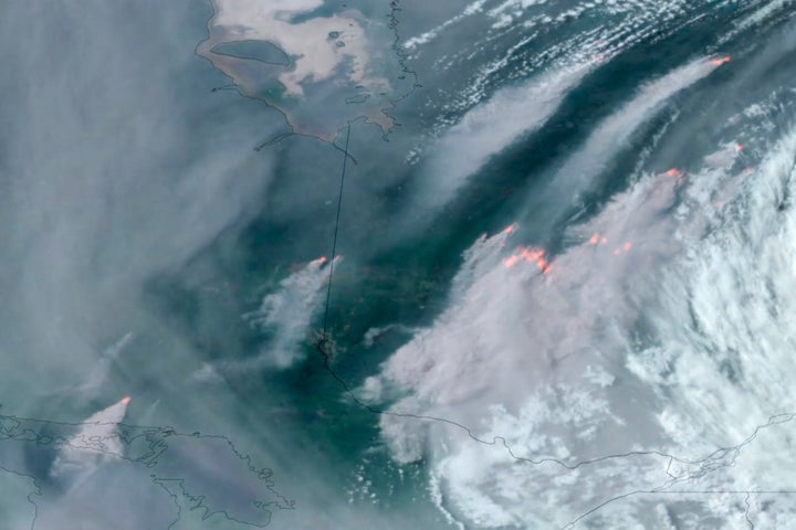 In this GOES-16 GeoColor and fire temperature satellite image taken Tuesday, June 6, 2023 at 6:40 p.m. EDT and provided by CIRA/NOAA, smoke from wildfires burning in the Canadian Provinces of Quebec, right, and Ontario, left, drift southward. (CIRA/NOAA via AP)