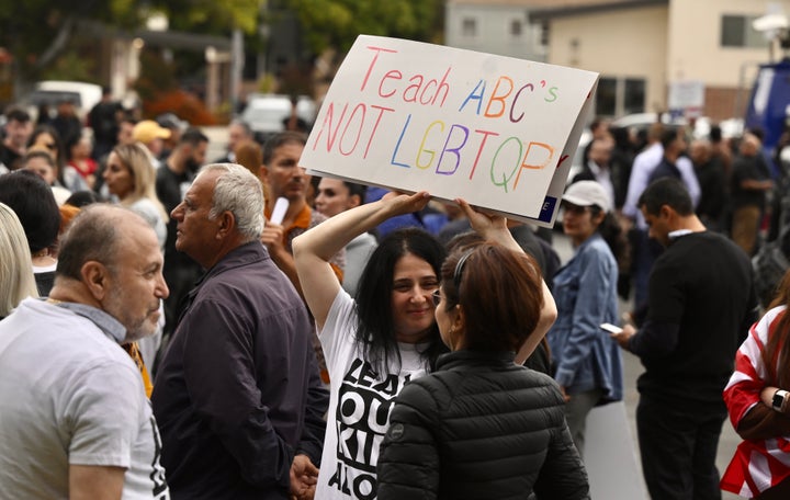 Un manifestant opposé à la déclaration du mois de la fierté du district scolaire brandit une pancarte.
