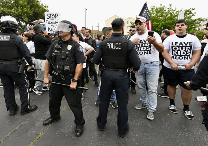 Protesters wear shirts reading "Leave our kids alone."