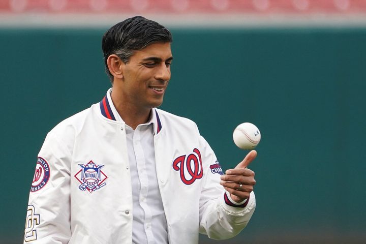Rishi Sunak tosses a baseball while attending a Washington Nationals baseball game during his visit to Washington DC.