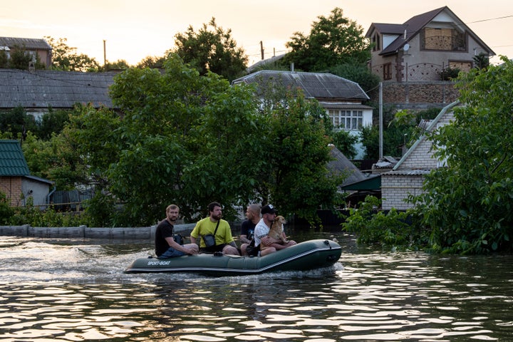 Volunteers evacuate a dog from a flooded neighborhood in Kherson, Ukraine, on June 7, 2023. 