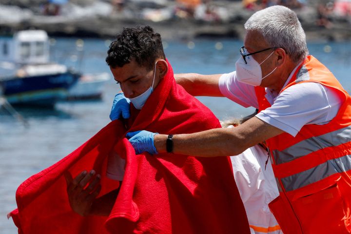 ΦΩΤΟΓΡΑΦΙΑ ΑΡΧΕΙΟΥ: Ένα μέλος του Ερυθρού Σταυρού βοηθά έναν μετανάστη μετά την αποβίβαση από σκάφος της ισπανικής ακτοφυλακής, στο λιμάνι Arguineguin, στο νησί Γκραν Κανάρια, Ισπανία, 30 Μαΐου 2023. REUTERS/Borja Suarez/File Photo