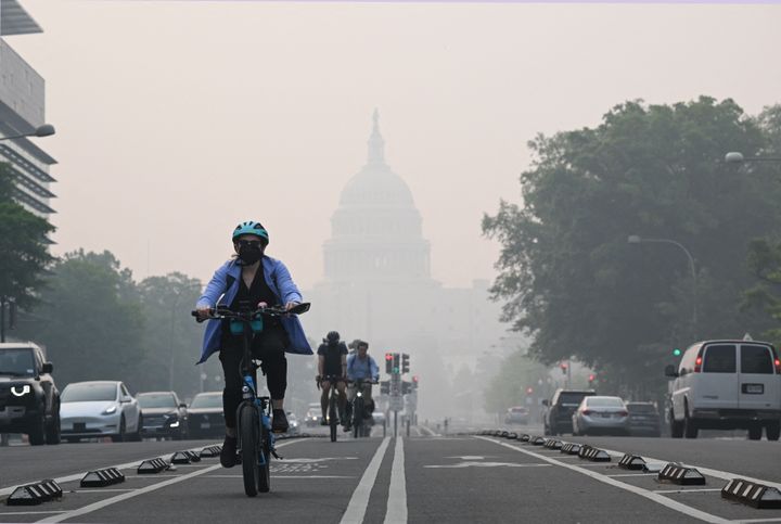 A cyclist rides under a blanket of haze partially obscuring the U.S. Capitol in Washington, D.C., on June 8. Smoke from Canadian wildfires has shrouded the East Coast.