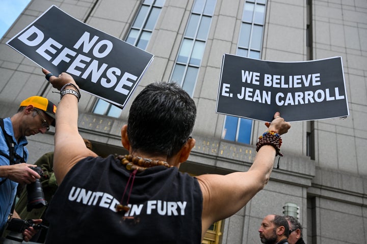 A protester holds up signs outside a Manhattan Federal Court after a jury found Trump liable for sexually abusing Carroll in a Manhattan department store in the 1990s.