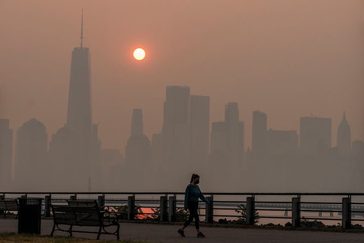 An orange sun rises behind One World Trade Center and the New York City skyline as smoke from Canadian wildfires fills the air on June 8, 2023. 