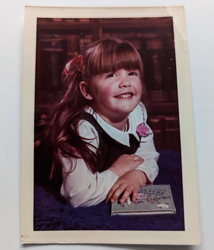 The author with her first love, a book, in her kindergarten photo