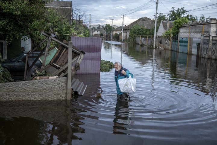 A local resident walks in a flooded street after the explosion at the Kakhovka hydropower plant unleashed floodwaters in Kherson, Ukraine on June 11, 2023. 
