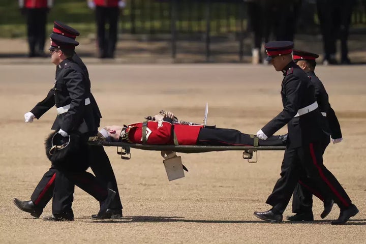 A trombone player of the military band is carried out on a stretcher after a faint during the Colonel's Review, the final rehearsal of the Trooping the Colour, the King's annual birthday parade, at Horse Guards Parade in London on June 10.
