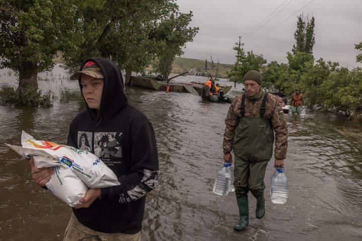 Ukrainian military carry humanitarian aid for residents, in a flooded area as the result of the Kakhovka dam destruction on June 12, 2023.
