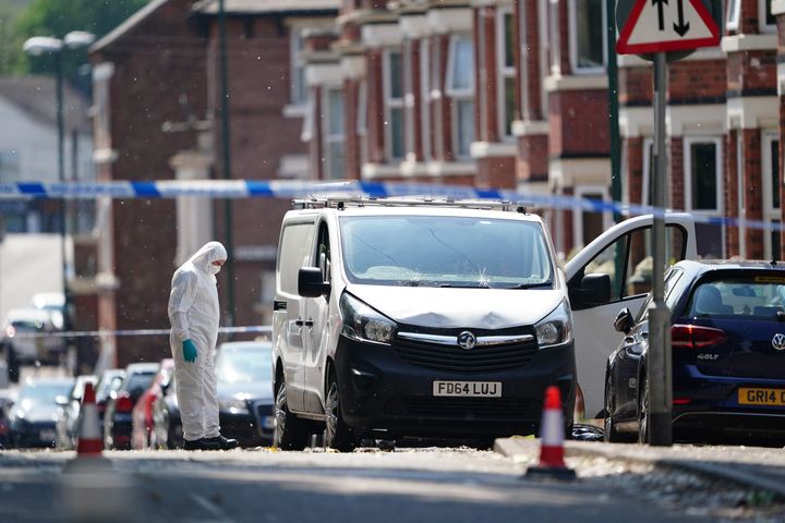 A police forensics officer searches a white van in Nottingham.